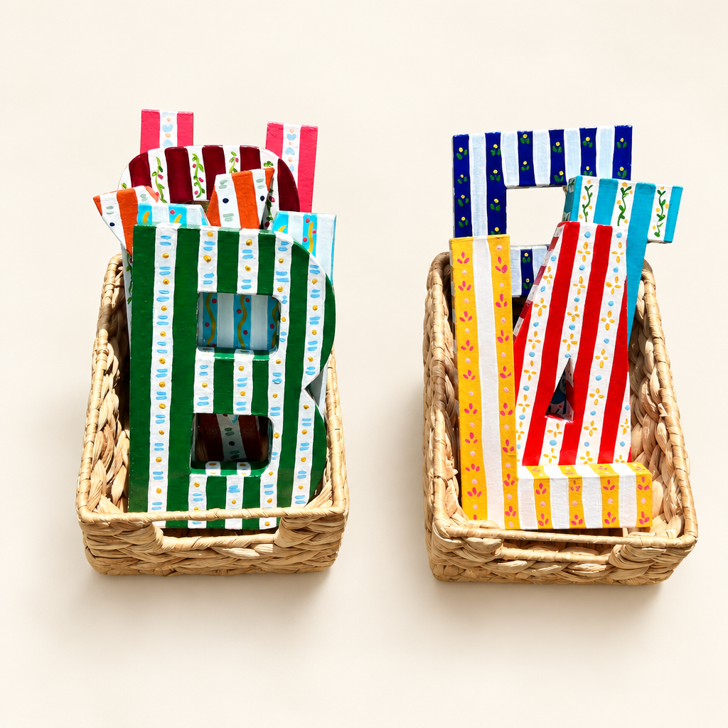 Two baskets of handpainted letters on a warm-white background
